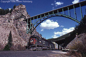 A train going under the Eagle River highway bridge.
